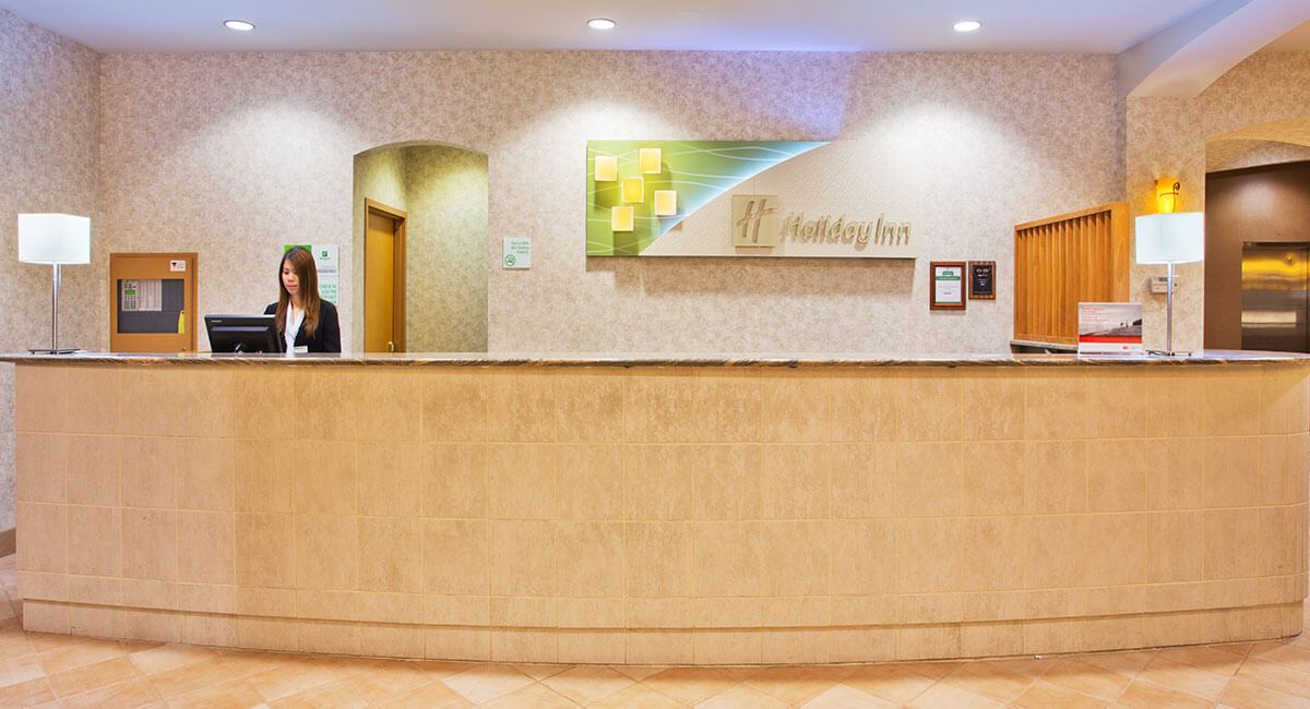 An employee overseeing the check-in desk at the Holiday Inn North Vancouver
