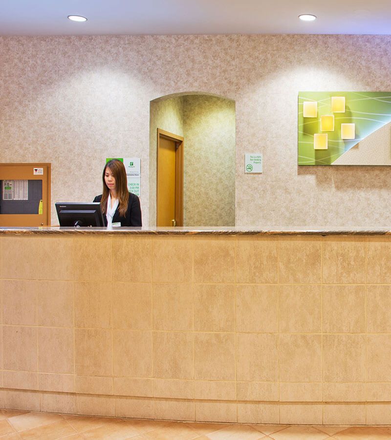 An employee behind the check-in desk at the Holiday Inn North Vancouver